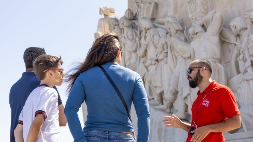 Guia a explicar monumento a turistas em Lisboa