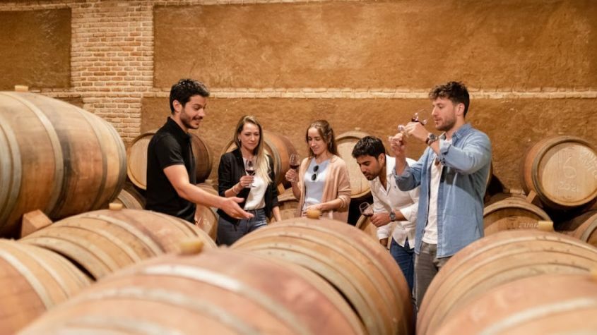 Grupo de turistas em prova de vinhos dentro de uma cave de vinhos em Madrid