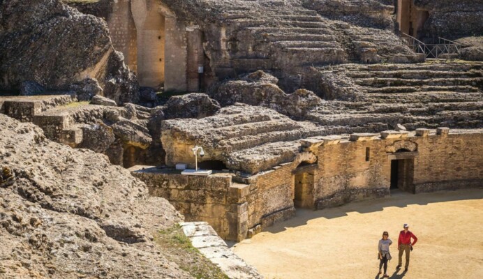 Casal turistas a explorarem ruinas em Itálica